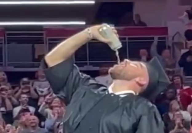 EXCLUSIVE: Travis Kelce FINALLY graduates college with brother Jason at the end of New Heights live show in Cincinnati - and Taylor Swift's boyfriend celebrates by necking a beer and screaming Beastie Boys lyrics!