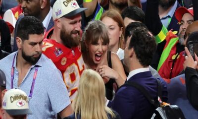 Travis Kelce couldn't help but smile at a Taylor Swift cardboard cutout at New Heights live show