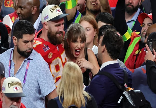 Travis Kelce couldn't help but smile at a Taylor Swift cardboard cutout at New Heights live show